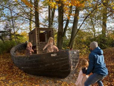 Børn og voksen leger på skib